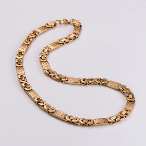 Macro view of gold stainless steel necklace with textured rectangular links and rings