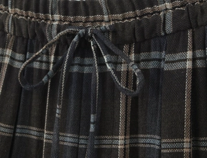 Close-up of elastic waistband with adjustable drawstring on plaid pattern trousers