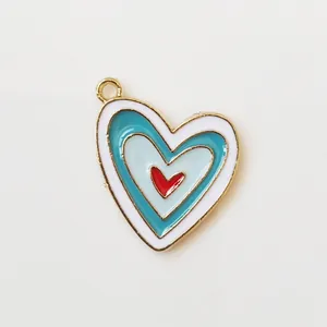 Detail of a layered enamel heart pendant with colorful nesting and golden metal ring