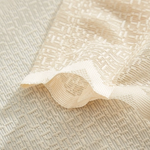 Close-up of beige lace fabric showing intricate geometric texture and mesh details