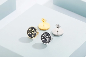 Detailed view of gold and silver Eye of Horus earrings with black enamel inlay