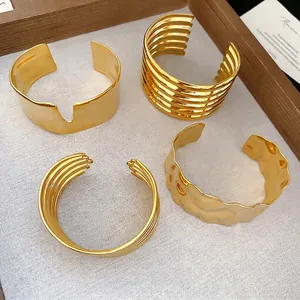 Set of four gold stainless steel textured cuff bracelets with minimalist wavy designs