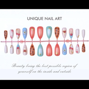 Detail of almond nail tips with 3D cherry patterns and floral relief embossed textures