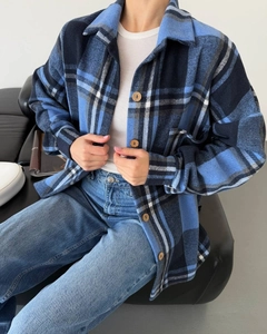 Detailed view of blue and white plaid flannel texture with buttons on a casual shacket