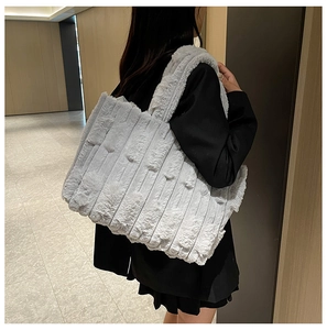 Detail of grey plush tote bag featuring soft vertical striped texture and large capacity