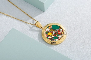 Macro view of gold stainless steel necklace featuring colorful mosaic tree pendant