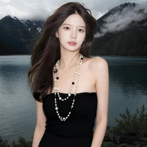 Long multilayer pearl necklace with floral pendant and number five detail on a model