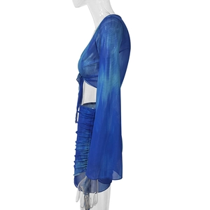 Detail view of blue tie-dye mesh set showing ruched skirt and flared sleeves textures