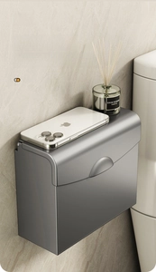 Close-up of wall-mounted dark gray tissue box with a flat top tray for phone and aromatics