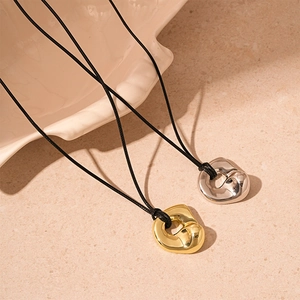 Irregular organic metal pendant necklace in gold and silver finish with black cord