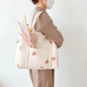 Detail of quilted cotton diaper bag with brown animal print and front pocket