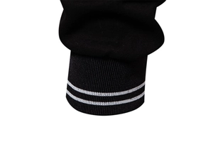 Close-up of black ribbed knit cuffs with double white stripes on long-sleeve sweatshirt