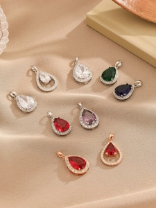 Detail shot of teardrop gemstone pendants in various colors and metallic finishes
