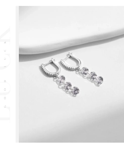 Close-up of S925 sterling silver drop earrings with triple round cubic zirconia stones