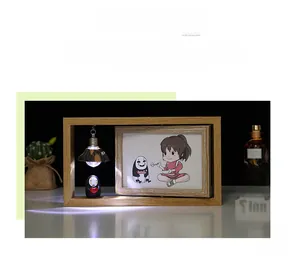 Gros plan d'un cadre photo en bois avec lanterne LED et décor du Voyage de Chihiro