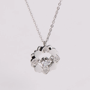 Macro shot of silver heart-shaped clover pendant with sparkling zircon inlays