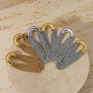 Elegant C-shaped stainless steel tassel earrings in gold and silver finishes on marble