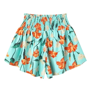 Dettaglio degli shorts a fiori a vita alta elasticizzata verde menta con gigli arancioni