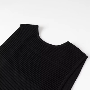Gros plan sur l'encolure en maille et la texture de l'épaule d'une robe noire sans manches