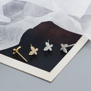Detail of s925 silver butterfly earrings in gold and silver set with zircons