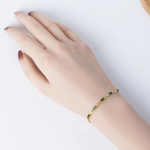 Macro detail of gold finish S925 silver bracelet with rectangular green zircon stones