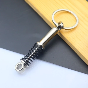 Detail of creative car shock absorber keychain with realistic metal spring and silver finish