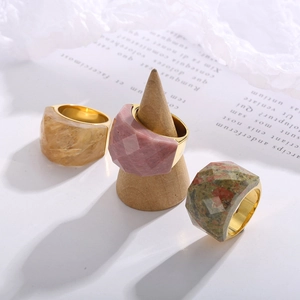 Detailed macro view of multifaceted colorful natural stones set in 18K gold plated rings