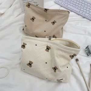 Detailed macro view of corduroy cosmetic bags with cute bear pattern and metal zipper