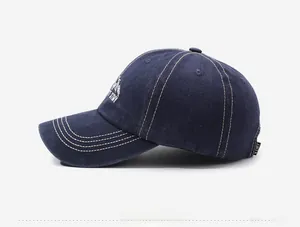 Detailed embroidery on vintage blue washed denim baseball cap with contrast stitching