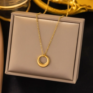 Minimalist gold circle pendant necklace on a premium leather jewelry box display