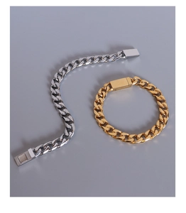 Macro detail of gold and silver cuban link bracelets with magnetic clasp closure