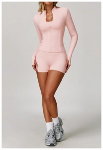 Detail of pink long sleeve yoga jacket with thumbholes and zip closure on high-stretch fabric