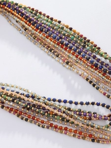 Detail of multi-layer natural stone beaded necklace with faceted gems and gold spacer beads
