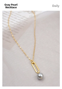Close-up of golden lip-shaped chain necklace with elegant grey pearl pendant details