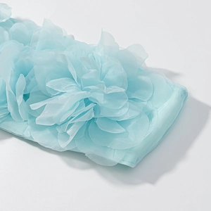 Detail of light blue 3D chiffon floral appliqué with soft layered fabric texture