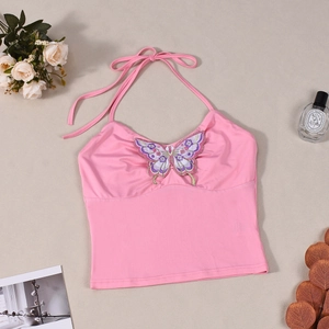 Detail van roze halter crop top met ingewikkelde paarse vlinderborduring op de stof