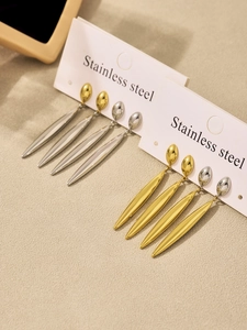 Detailed view of teardrop earrings in gold and silver finish on display cards
