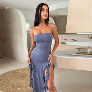 Detail of grey-blue tube dress featuring ruched fabric and ruffled side slit accents