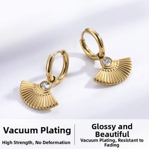 Macro detail of fan-shaped gold titanium steel earrings with zircon stone inlay