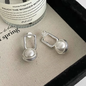 Elegant S925 sterling silver geometric pearl earrings on a light fabric background
