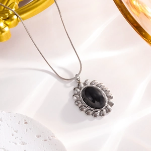 Macro view of vintage silver twisted edge pendant with central oval black onyx stone