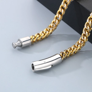 Detail view of the spring buckle clasp on a two-tone gold and silver stainless steel chain