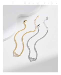 Detail of adjustable silver and gold heart bracelets with white zircon inlays