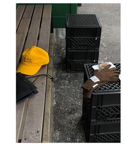 Close-up of brown wool knit gloves and yellow embroidered cap on a park bench