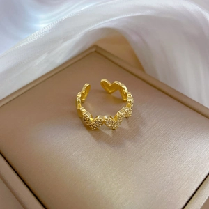 Macro shot of gold heart ring featuring micro-pave cubic zirconia on silk background