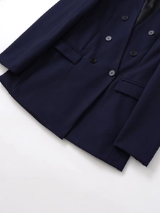 Dettaglio del blazer doppiopetto blu navy che mostra i bottoni e la trama del tessuto