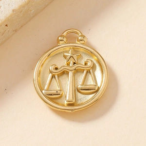 Macro shot of 18K gold-plated stainless steel Libra zodiac pendant with relief pattern