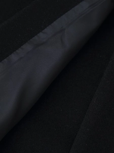 Macro view of black wool coat fabric texture and smooth inner synthetic lining