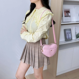 Stylish heart shaped pink quilted crossbody bag with adjustable strap and V-stitch pattern