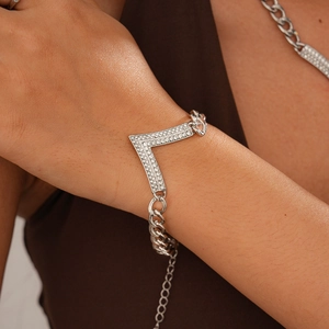 Close-up of silver-tone V-shaped bracelet with cubic zirconia on a Cuban link chain